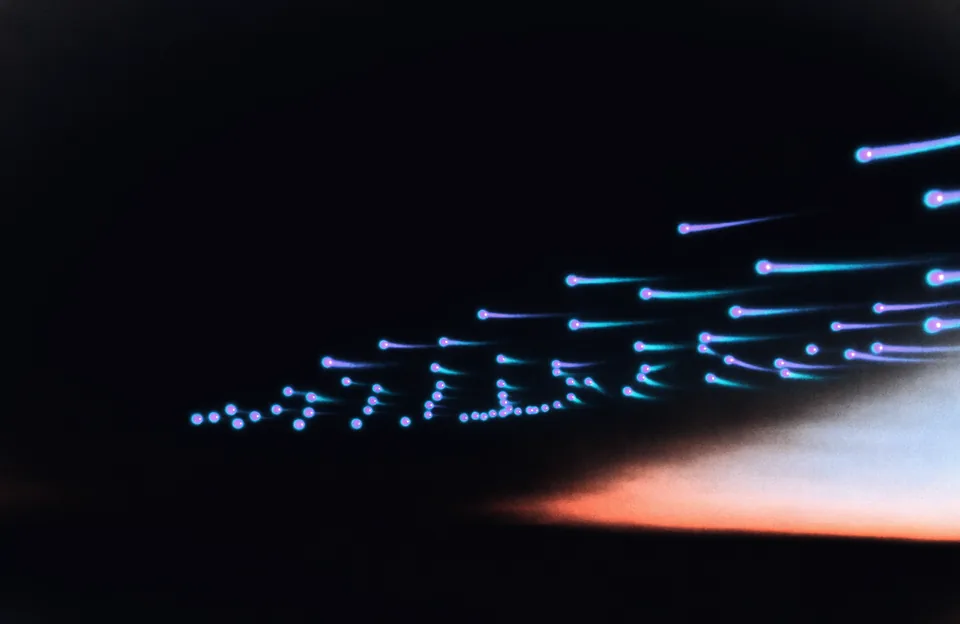Abstract illustration: a procession of luminous orbs drifting across a night sky toward a warm dawn glow